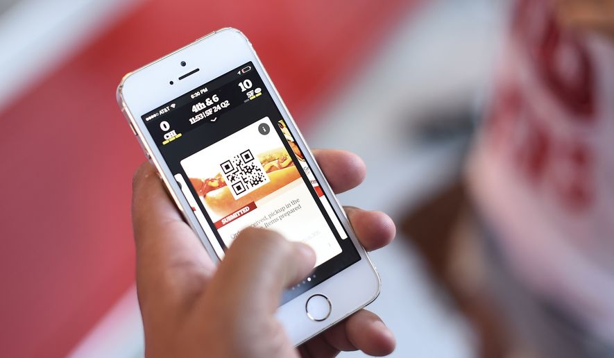 In this Sept. 14, 2014, photo, a fan uses an app on a smartphone to order food and drinks at Levi's Stadium during an NFL football game between the San Francisco 49ers and the Chicago Bears in Santa Clara, Calif. (AP Photo/Noah Berger) ** FILE **