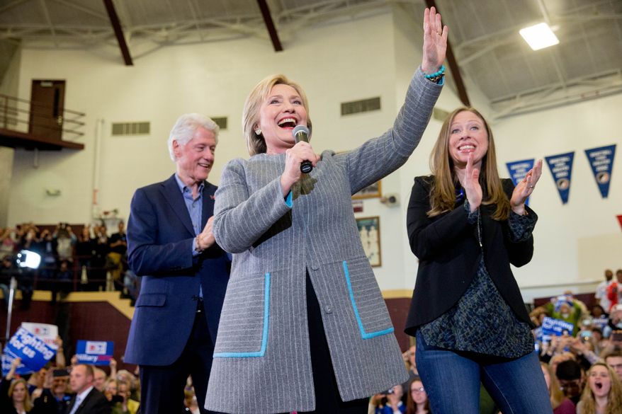 Democratic presidential candidate Hillary Clinton, accompanied by her husband, former President Bill Clinton and their daughter Chelsea Clinton, waves as she arrives to speak at a rally at Abraham Lincoln High School in Des Moines, Iowa, Sunday, Jan. 31, 2016. (AP Photo/Andrew Harnik)