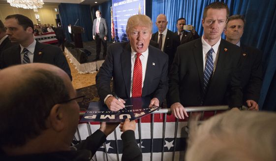 Republican presidential candidate Donald Trump signs autographs during a campaign stop at the Radisson Hotel, Friday, Jan. 29, 2016, in Nashua, N.H. (AP Photo/John Minchillo)
