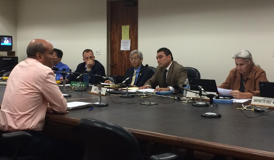 Hakim Ouansafi, left, executive director of the Hawaii Public Housing Authority, talks to a panel of Hawaii lawmakers on Monday, Feb. 1, 2016, in Honolulu. Hawaii officials are debating how to chip away at a 60,000-unit housing shortage over the next five years. (AP Photo/By Cathy Bussewitz)