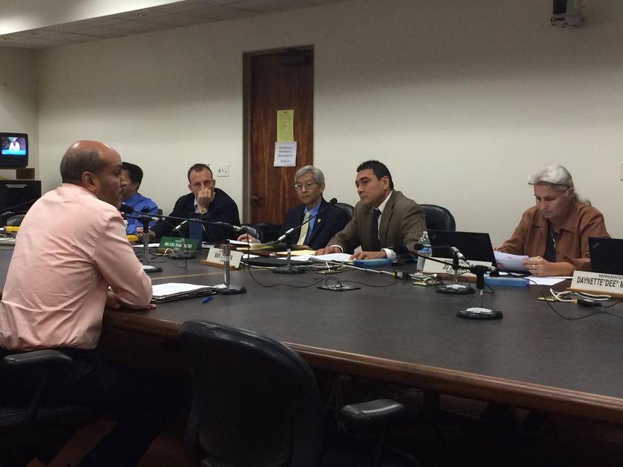 Hakim Ouansafi, left, executive director of the Hawaii Public Housing Authority, talks to a panel of Hawaii lawmakers on Monday, Feb. 1, 2016, in Honolulu. Hawaii officials are debating how to chip away at a 60,000-unit housing shortage over the next five years. (AP Photo/By Cathy Bussewitz)