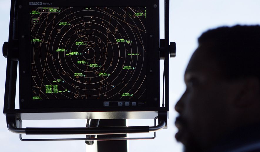 FILE - In this Sept. 18, 2008, file photo an air traffic controller stands beneath a radar screen in the control tower at Washington's Reagan National Airport. House Transportation Committee Chairman Rep. Bud Shuster, R-Pa., is launching a push this week to take control of that system away from the government and hand it to a non-profit corporation directed by the airlines, airports, and labor unions, among others. (AP Photo/Charles Dharapak, File)