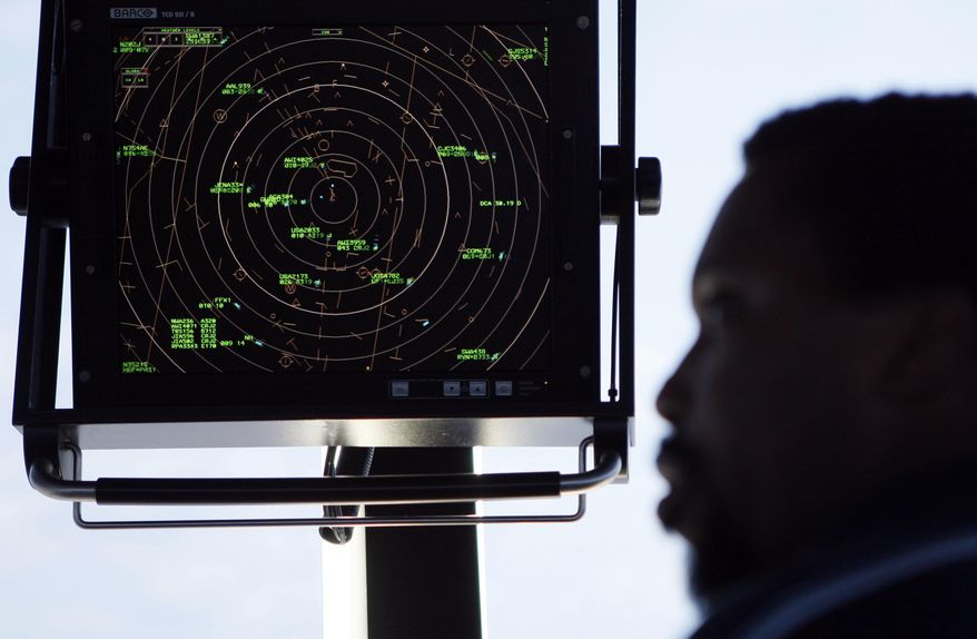 FILE - In this Sept. 18, 2008, file photo an air traffic controller stands beneath a radar screen in the control tower at Washington's Reagan National Airport. House Transportation Committee Chairman Rep. Bud Shuster, R-Pa., is launching a push this week to take control of that system away from the government and hand it to a non-profit corporation directed by the airlines, airports, and labor unions, among others. (AP Photo/Charles Dharapak, File)