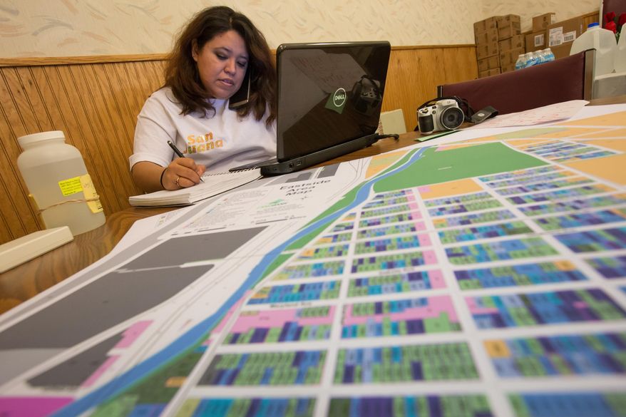San Juana Olivares Chair of the Genesee County Community Hispanic Collaborative works to gather volunteers and keep track of water deliveries coming into St. Mary's Church in Flint's east side on Jan. 26, 2016. Michigan officials say identification isn't being required to get bottled water in Flint as part of an effort to ensure all residents, including immigrants living illegally in the country, get safe water amid the city's crisis with lead-tainted water. (Ryan Garza/Detroit Free Press via AP) DETROIT NEWS OUT; TV OUT; MAGS OUT; NO SALES; MANDATORY CREDIT DETROIT FREE PRESS