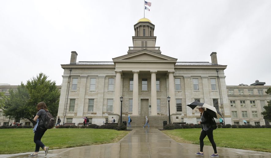 In this Oct. 2, 2014 file photo, students walk across campus at the University of Iowa in Iowa City, Iowa. (AP Photo/Charlie Neibergall, File)