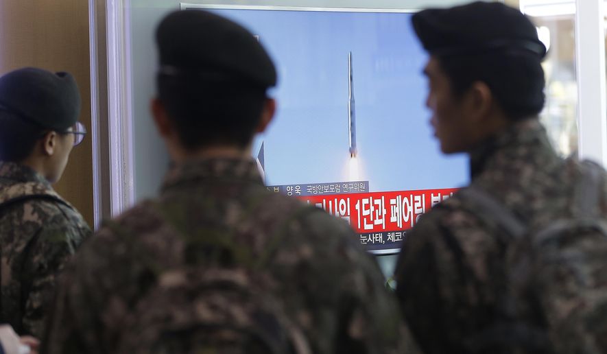 South Korean army soldiers watch a news program about North Korea&#39;s rocket launch Sunday at Seoul Railway Station. (Associated Press)
