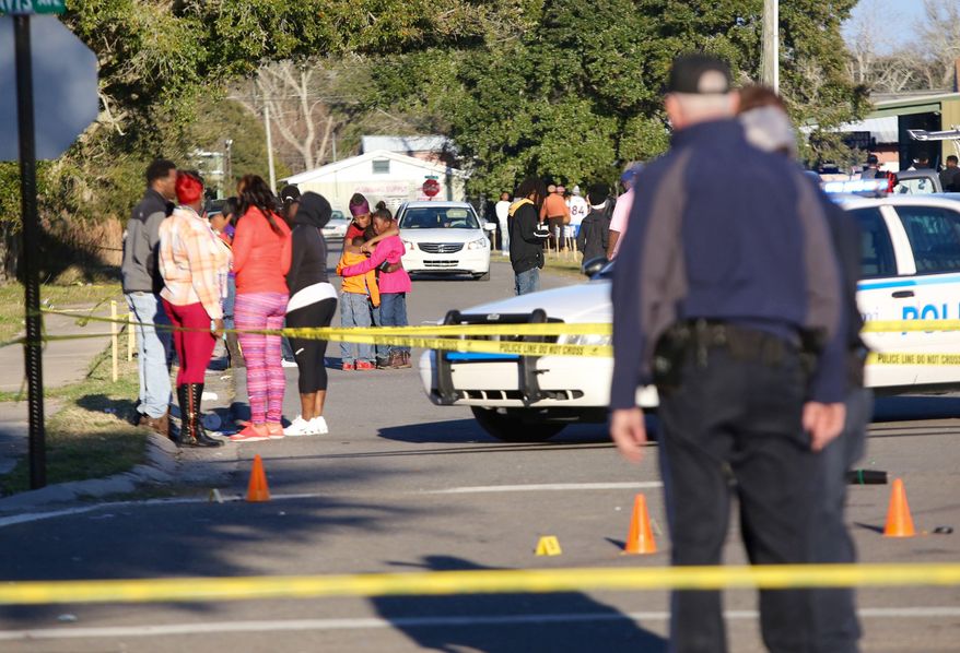 A woman embraces two children near the intersection of Davis Avenue and Ladnier Street in Pass Christian after a shooting on Sunday, Feb. 7, 2016. South Mississippi police say a shooting after a Mardi Gras parade in Pass Christian has left two people dead and four others wounded. (Amanda McCoy/The Sun Herald via AP) /The Sun Herald via AP) LOCAL TELEVISION OUT; MANDATORY CREDIT: MISSISSIPPI PRESS OUT; LOCAL TELEVISION OUT WLOX, LOCAL ONLINE OUT; GULFLIVE.COM OUT