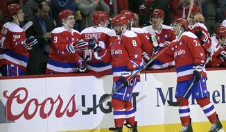 Washington Capitals left wing Alex Ovechkin (8), of Russia, celebrates his goal with teammate Dmitry Orlov (9), also of Russia, and others during the second period of an NHL hockey game against the Philadelphia Flyers, Sunday, Feb. 7, 2016, in Washington. (AP Photo/Nick Wass)