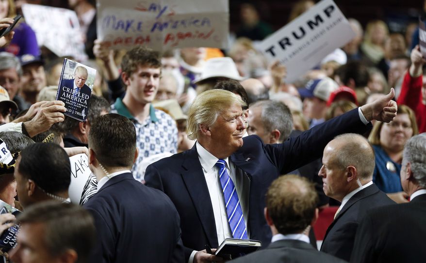 Republican presidential candidate Donald Trump gives a thumbs up to a supporter as he signs autograph after a rally Friday, Feb. 5, 2016, in Florence, S.C. (AP Photo/John Bazemore)