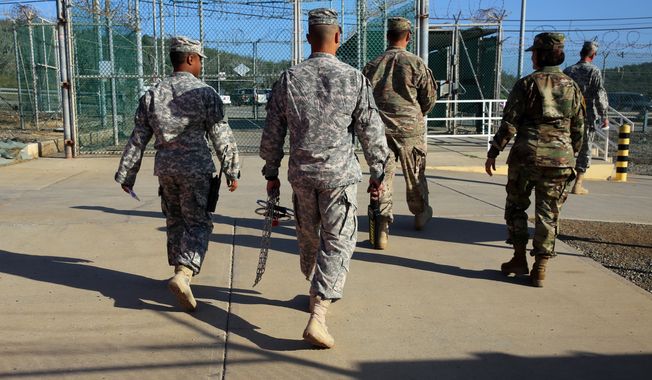 In this Feb. 2, 2016 photo, military guards exit an area known as Camp Delta at the Guantanamo Bay detention center, in Cuba. After 14 years, the detention center appears to be winding down despite opposition in Congress to President Barack Obama&#x27;s intent to close the facility and confine the remaining prisoners someplace else. (AP Photo/Ben Fox)