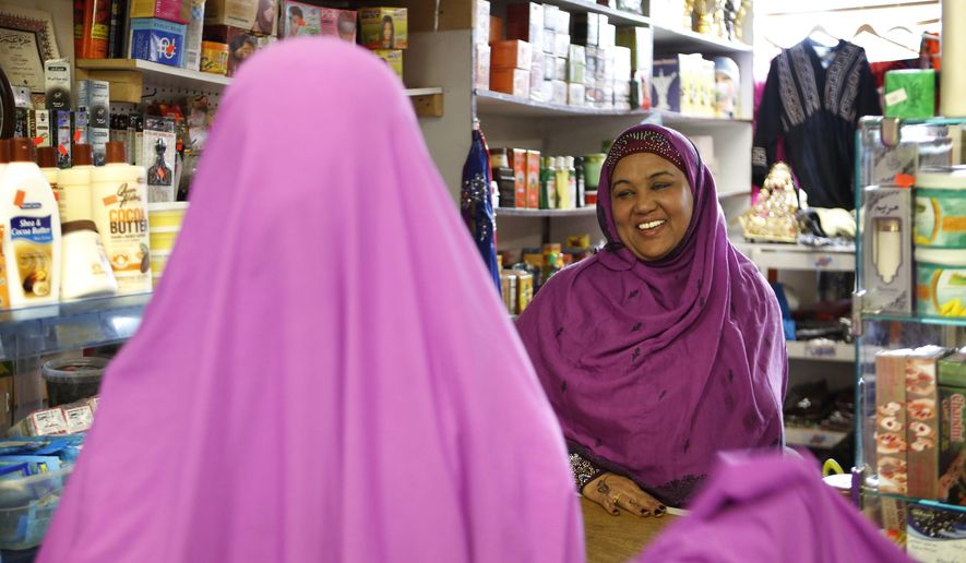 In this Tuesday, Jan. 26, 2016 photo, Shukri Abasheikh, owner of Mogadishu Store, speaks with a customer in Lewiston, Maine. "When Somalis came in, Lewiston people, Maine people, they think they need welfare but we don't need welfare. We need jobs. We need peace. We need education," said Abasheikh, who worked as a janitor before achieving her dream of running her own business. (AP Photo/Robert F. Bukaty)