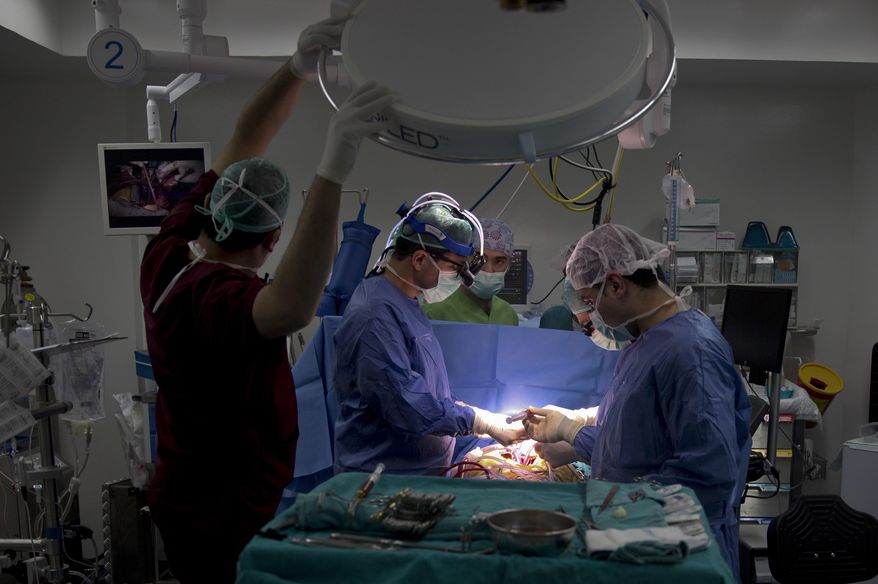 In this Thursday, Jan. 28, 2016 photo, Palestinian cardiovascular surgeon Saleem Haj-Yahia, left, performs open-heart surgery at An-Najah University hospital in the West Bank city of Nablus. Dr. Haj-Yahia is the first surgeon to perform a successful artificial heart transplant in the West Bank. (AP Photo/Majdi Mohammed)