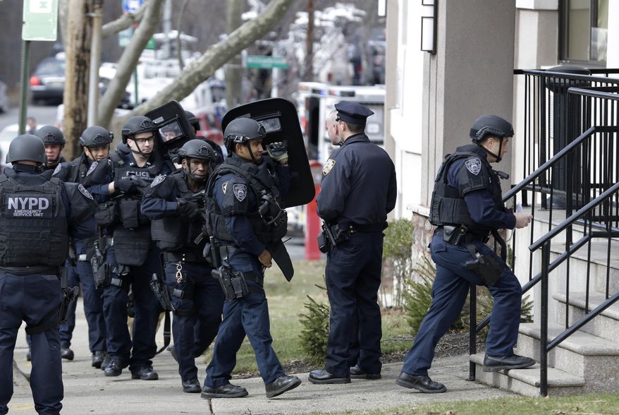 New York City police enter a hotel, Wednesday, Feb. 10, 2016, while searching for a murder suspect in the Staten Island borough of New York. (AP Photo/Seth Wenig)