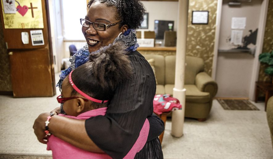 In this Thursday, Jan. 21, 2016 photo, Natasha and her daughter embrace each other before the school bus arrives at the Bethesda Mission Women and Children's Shelter in Harrisburg, Pa. The 10-year-old girl is one of Pennsylvania's roughly 22,000 homeless students in grades pre-K through 12. (Dan Gleiter/PennLive.com via AP)