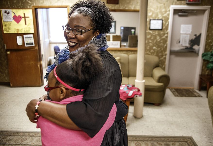 In this Thursday, Jan. 21, 2016 photo, Natasha and her daughter embrace each other before the school bus arrives at the Bethesda Mission Women and Children's Shelter in Harrisburg, Pa. The 10-year-old girl is one of Pennsylvania's roughly 22,000 homeless students in grades pre-K through 12. (Dan Gleiter/PennLive.com via AP)