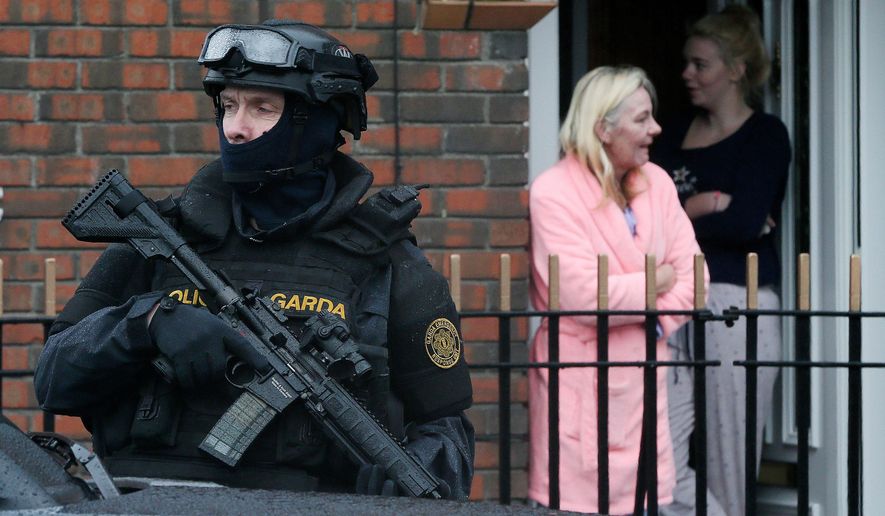 Armed Gardai from the force's Emergency Response Unit on patrol, as gang violence has resulted in two murders in four days, in Dublin, Ireland, Tuesday, Feb. 9, 2016. As Dublin's gangland tensions deepened, Ireland's justice minister urged gang members to seek police protection Tuesday after gunmen shot to death the brother of a Dublin crime kingpin in apparent retaliation for last week's deadly attack on a boxing ceremony. Police have put in roadblocks, increased surveillance on high-profile targets and placed an imprisoned relative of a crime boss into protective custody. (Niall Carson/PA via AP) UNITED KINGDOM OUT - NO SALES - NO ARCHIVES