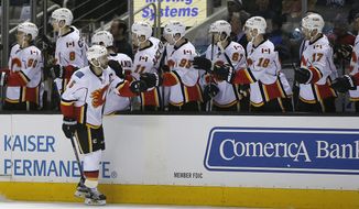 Calgary Flames defenseman Mark Giordano (5) celebrates with his teammates after scoring a goal against the San Jose Sharks during the first period of an NHL hockey game in San Jose, Calif., Thursday, Feb. 11, 2016. (AP Photo/Tony Avelar)