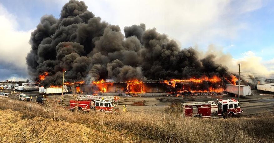 This photo provided by Nick Bowling shows a large fire at an industrial park in central New Jersey that closed down a major roadway and sent clouds of black smoke billowing into the sky. A stretch of Route 206 was closed in Hillsborough Thursday, Feb. 11, 2016, and smoke from the fire at Veterans Industrial Park can be seen for miles. No injuries have been reported, but witnesses say they've heard explosions that shook the ground and rattled windows. (Nick Bowling via AP)