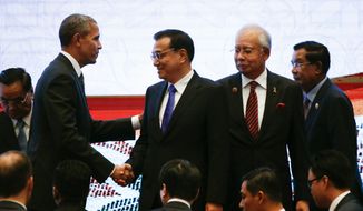 In this Nov. 22, 2015, file photo, U.S. President Barack Obama, left, shakes hands with Chinese Premier Li Keqiang, second left, while Malaysian Prime Minister Najib Razak, second right, and Laotian Prime Minister Thongsing Thammavong look on during the 10th East Asia Summit at the 27th ASEAN Summit in Kuala Lumpur, Malaysia. (AP Photo/Vincent Thian, File)