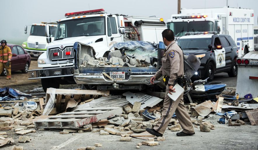 Emergency personnel work at the scene of a crash, one of several separate collisions, on Highway 59 in Merced County, Calif., Saturday, Feb. 13, 2016. The CHP says there was fog on the highway around the time of the crashes, but the cause remains under investigation. (Andrew Kuhn/Merced Sun-Star via AP)