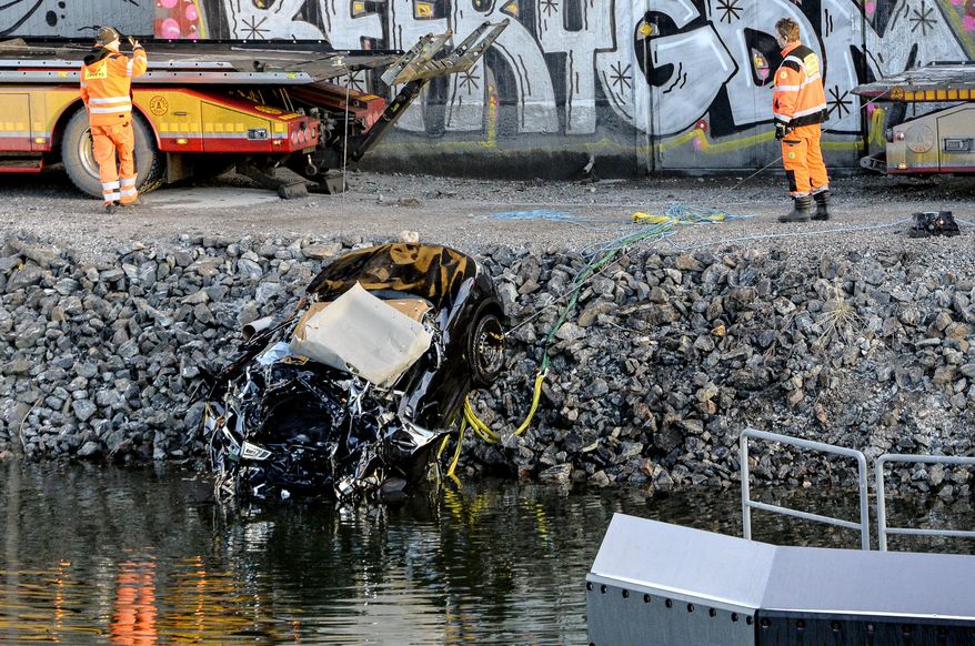 A badly damaged car is towed up from the canal under the E4 highway bridge in Sodertalje, Sweden, Saturday, Feb.13, 2016. Swedish police say five people have been killed when their car plunged more than 25 meters (82 feet) from a highway bridge into a canal in the capital of Stockholm. (Johan Nilsson/TT News Agency via AP) SWEDEN OUT