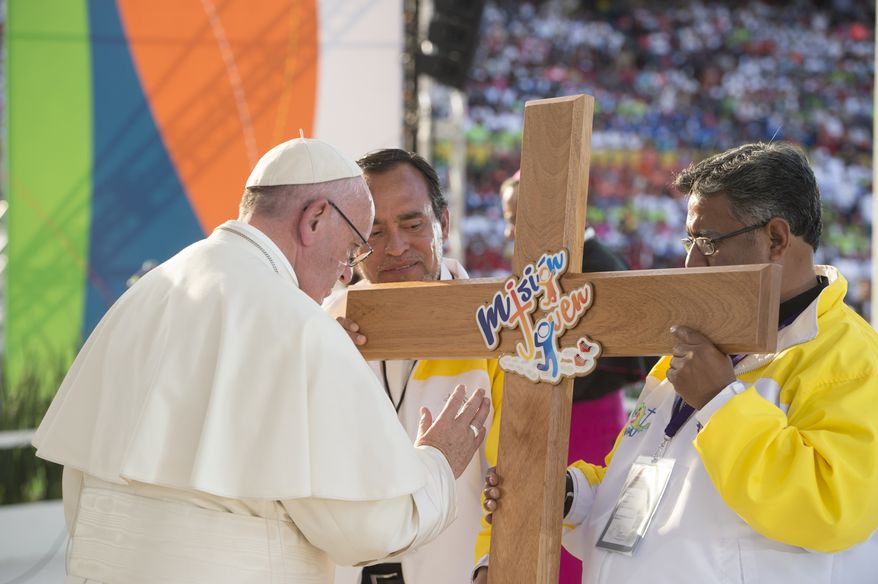 In this Feb. 16, 2016 photo, Pope Francis blesses a wooden cross during a meeting with Mexican youth at the Jose Maria Morelos y Pavon Stadium in Morelia, Mexico, Tuesday, Feb. 16, 2016. (L'Osservatore Romano/Pool Photo via AP)