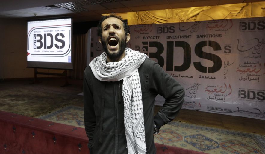 FILE - In this April 20, 2015, file photo, an Egyptian man shouts anti-Israeli slogans in front of banners with the Boycott, Divestment and Sanctions (BDS) logo during the launch of the Egyptian campaign that urges boycott, divestment and sanctions against Israel and Israeli-made goods, at the Egyptian Journalists’ Syndicate in Cairo, Egypt. Israel is using its world-leading expertise in cyber security to take on the growing threat posed by the global pro-Palestinian movement to boycott Israel. (AP Photo/Amr Nabil, File)