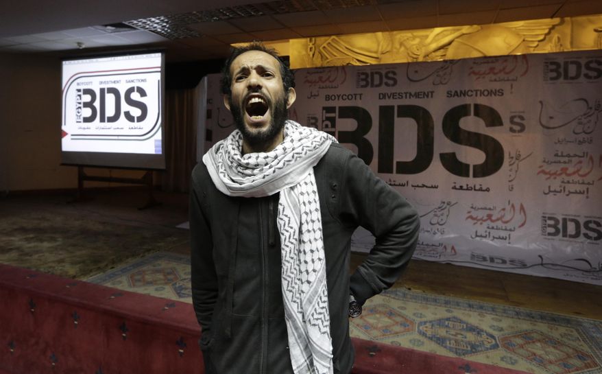 FILE - In this April 20, 2015, file photo, an Egyptian man shouts anti-Israeli slogans in front of banners with the Boycott, Divestment and Sanctions (BDS) logo during the launch of the Egyptian campaign that urges boycott, divestment and sanctions against Israel and Israeli-made goods, at the Egyptian Journalists’ Syndicate in Cairo, Egypt. Israel is using its world-leading expertise in cyber security to take on the growing threat posed by the global pro-Palestinian movement to boycott Israel. (AP Photo/Amr Nabil, File)