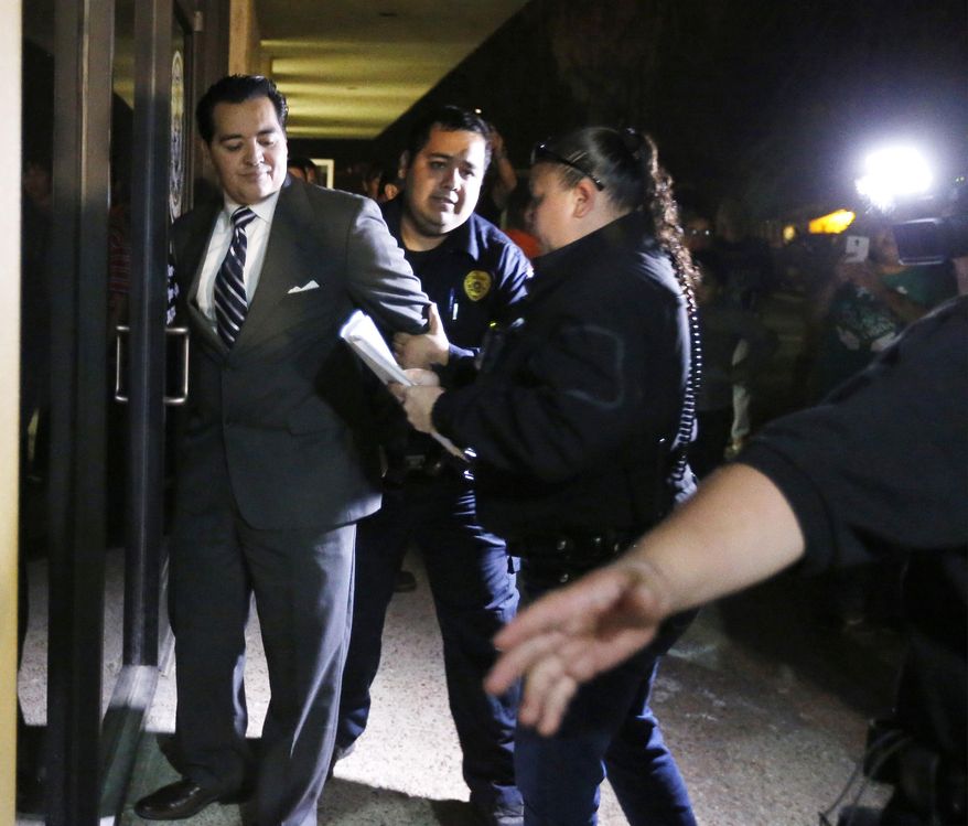 In this photo taken on Tuesday, Feb. 16, 2016, Crystal City Mayor Ricardo Lopez is taken away from city hall by police, in Crystal City, Texas, after allegedly disrupting a City Council meeting while fighting a recall effort that began before his indictment this month in a public corruption investigation that has ensnarled him and most of the council. (Kin Man Hui /The San Antonio Express-News via AP) RUMBO DE SAN ANTONIO OUT; NO SALES; MANDATORY CREDIT