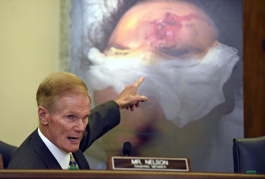 FILE - In this Tuesday, June 23, 2015, file photo, while speaking during a Senate Commerce, Science, and Transportation Committee hearing in Washington, Sen. Bill Nelson, D-Fla., points to the injury on a victim who was hit by shrapnel when a car's Takata air bag inflated. As the Takata air bag saga drags on, concerns are growing that tens of millions of U.S. drivers with cars that haven’t been recalled could be at risk of death or injury from the potentially defective devices. (AP Photo/Susan Walsh, File)