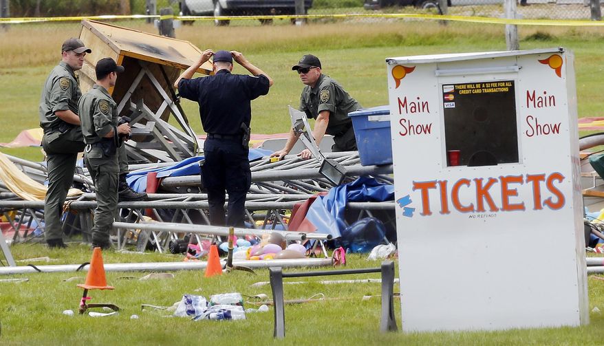 FILE - In a Aug. 4, 2015 file photo, investigators work at the scene of a circus tent that collapsed, killing a father and his 6-year-old daughter in Lancaster, N.H. Federal safety officials have proposed more than $33,000 in fines against a Florida-based circus operator for the tent collapse. The Occupational Safety and Health Administration said Thursday, Feb. 18, 2016, that Sarasota-based Walker International Events failed to properly erect the tent and ignored severe weather and high-wind warnings from the National Weather Service. (AP Photo/Jim Cole, File)