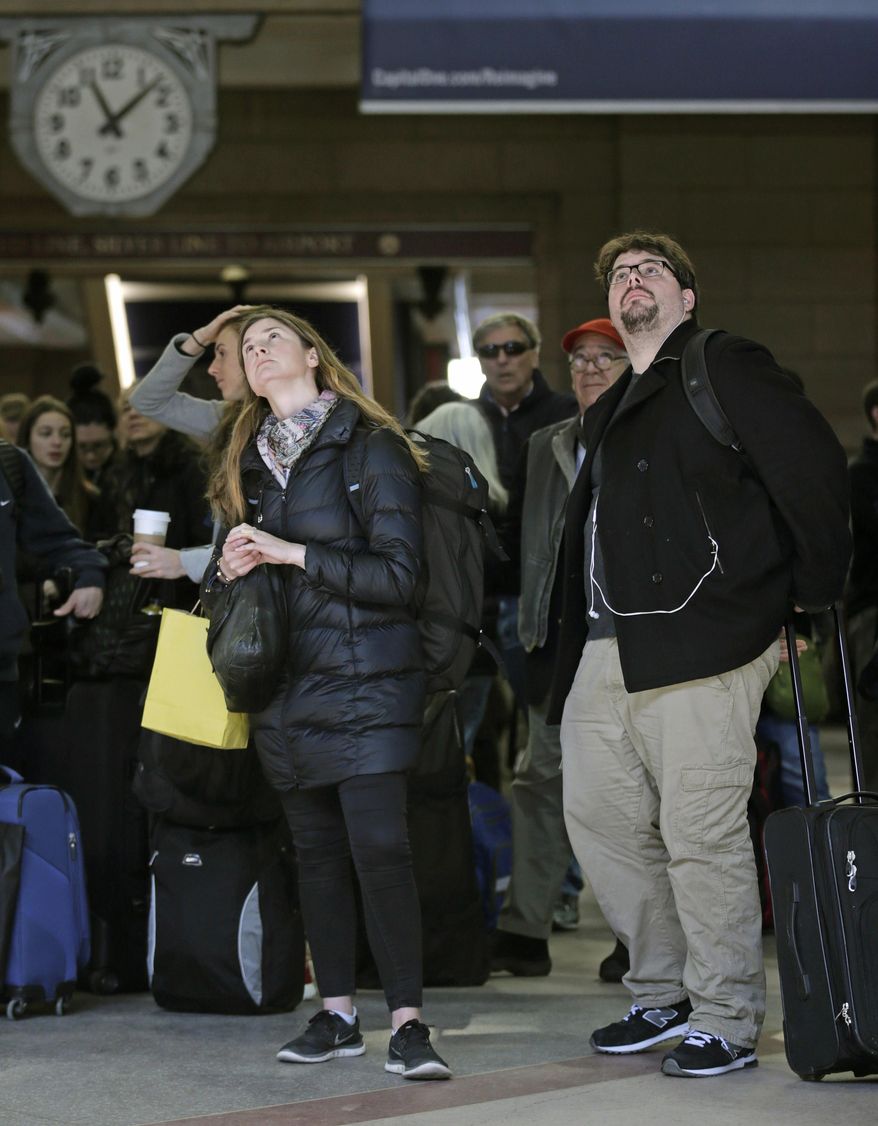 With many delays and cancelations posted, travelers watch the train departure board at South Station in Boston, Thursday, Feb. 18, 2016. Amtrak warned travelers of delays due to a signal problems at South Station. Engineers are working to fix the malfunction, significantly limiting the number of trains entering and leaving Boston, according to Amtrak. (AP Photo/Charles Krupa)