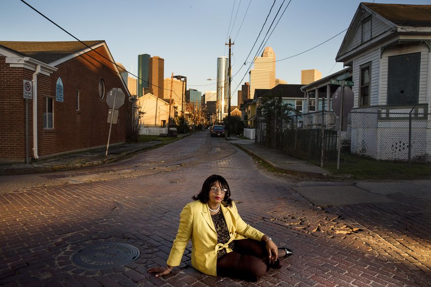 In this Friday, Feb. 12, 2016 photo, Freedmen's Town Preservation Coalition President Dorris Ellis Robinson sits at the intersection of Wilson Street and Andrews Street in Houston. She has been leading the effort to save the brick streets in Freedmen's Town and at one point laid down in the road to prevent crews from removing them. But the battle over the bricks, which has moved to the courts, is just the latest chapter in a long-running conflict over the survival of Houston's oldest African-American community. (Michael Ciaglo/Houston Chronicle via AP)