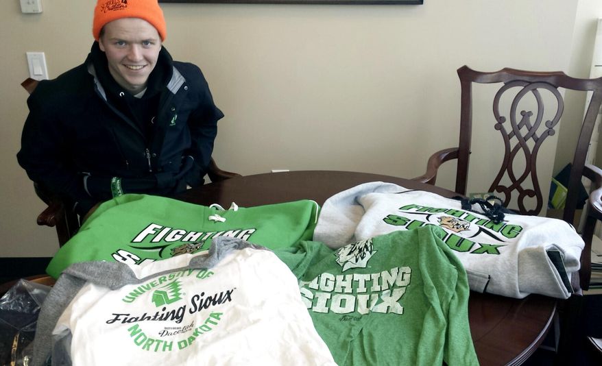 In this Feb. 9, 2016 photo provided by Marlys Lord Carlson, University of North Dakota freshman Nick Carlson smiles over his haul of UND Fighting Sioux gear that he bought at Ralph Engelstad Arena in Grand Forks, N.D. The merchandise is part of the Dacotah Legacy Collection that includes a limited number of items featuring the nickname that was retired more than three years ago after the NCAA deemed the logo hostile and abusive. Most of the items sold out in one day. (Marlys Lord Carlson /Marlys Lord Carlson Photography via AP)