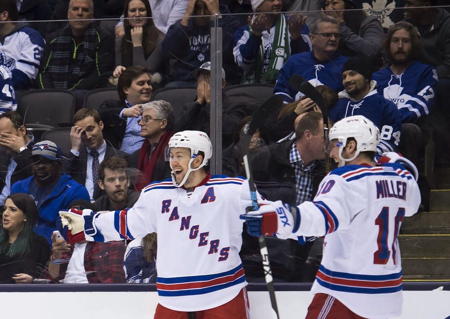 New York Rangers center Derek Stepan, left, celebrates his goal against the Toronto Maple Leafs with teammate J.T. Miller (10) during the third period of an NHL hockey game Thursday, Feb. 18, 2016, in Toronto. (Nathan Denette/The Canadian Press. via AP)