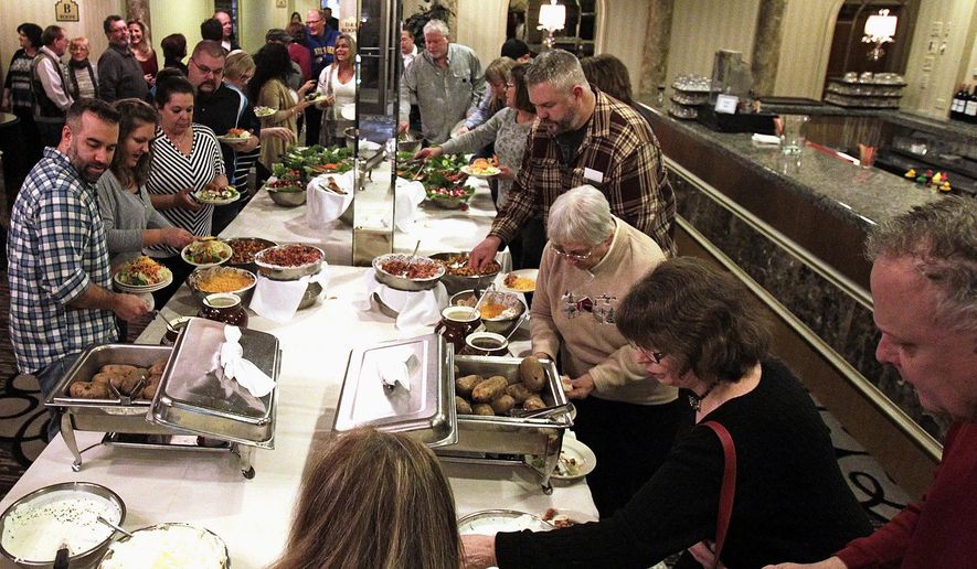 ADVANCE FOR USE SUNDAY, FEB. 21 AND THEREAFTER - In this Feb. 6, 2016 photo, attendees at the Crystal Lake Lions Club's 17th annual winter steak fry follow down the line, filling their plates with food in Crystal Lake, Ill. Service clubs, including the Crystal Lake Lions Club, McHenry Kiwanis Club and Woodstock Kiwanis Club, have struggled to grow membership in recent years. (Matthew Apgar/Northwest Herald via AP) CHICAGO TRIBUNE OUT, MANDATORY CREDIT