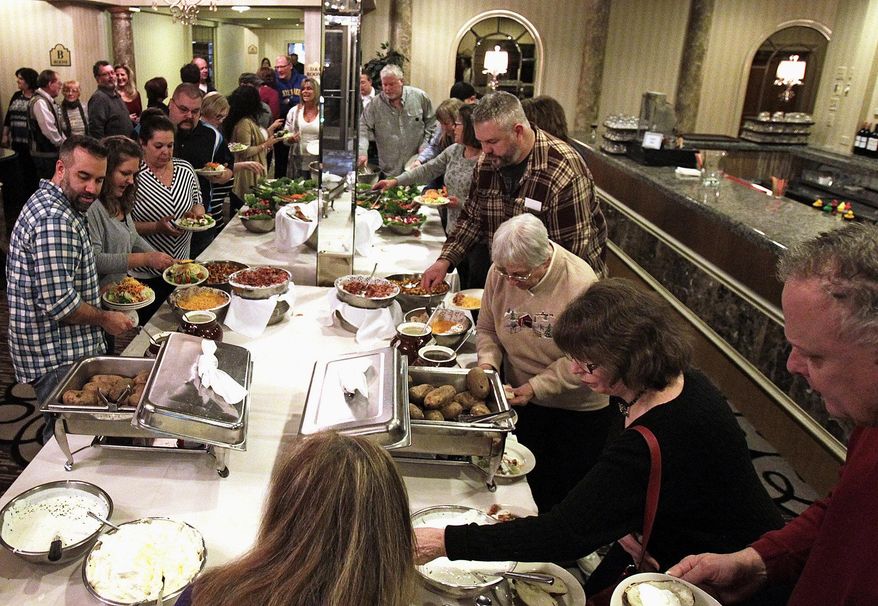 ADVANCE FOR USE SUNDAY, FEB. 21 AND THEREAFTER - In this Feb. 6, 2016 photo, attendees at the Crystal Lake Lions Club's 17th annual winter steak fry follow down the line, filling their plates with food in Crystal Lake, Ill. Service clubs, including the Crystal Lake Lions Club, McHenry Kiwanis Club and Woodstock Kiwanis Club, have struggled to grow membership in recent years. (Matthew Apgar/Northwest Herald via AP) CHICAGO TRIBUNE OUT, MANDATORY CREDIT