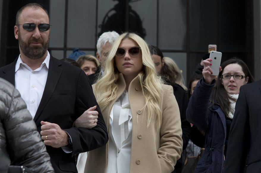 Pop star Kesha, center, leaves Supreme court in New York, Friday, Feb. 19, 2016. Kesha is fighting to wrest her career away from a hitmaker she says drugged, sexually abused and psychologically tormented her _ and still has exclusive rights to make records with her. Producer Dr. Luke says the singer is slinging falsehoods and ruining his reputation to try to weasel out of her recording contract and strike a new deal. (AP Photo/Mary Altaffer)