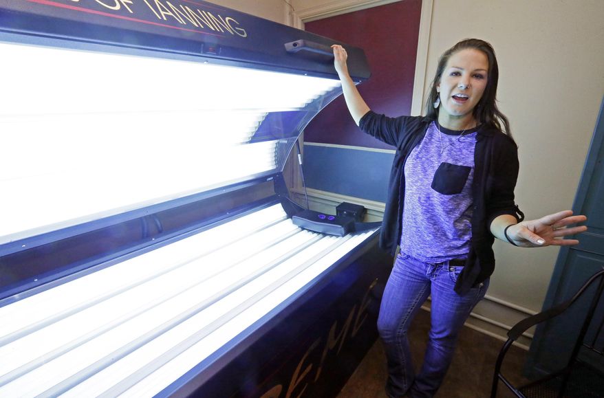 Linzy Rayfield, manager of Sun Gallery Tanning Studio in Ridgeland, Miss., stands at a level three tanning bed as she explains the company's safety steps Friday, Feb. 19, 2016. The Mississippi Dermatology Association, Mississippi State Department of Health and the American Cancer Society, citing health risks, have joined in an effort get lawmakers to support legislation that would ban anyone under age 18 from using indoor tanning beds and lamps even once. (AP Photo/Rogelio V. Solis)