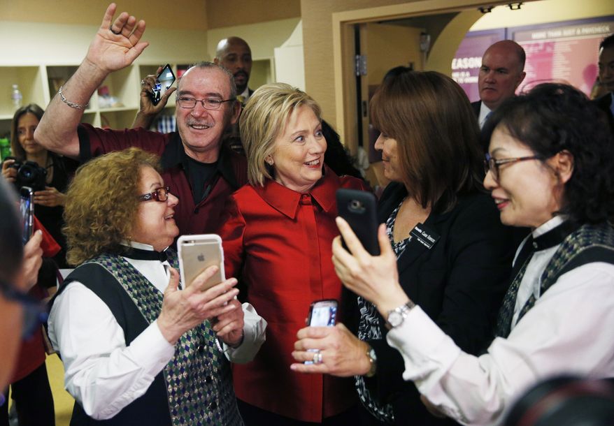 Democratic presidential candidate Hillary Clinton, reacts as employees of Harrah's Las Vegas surround her during a visit to the hotel and casino on the day of the Nevada Democratic caucus, Saturday, Feb. 20, 2016, in Las Vegas. (AP Photo/John Locher)
