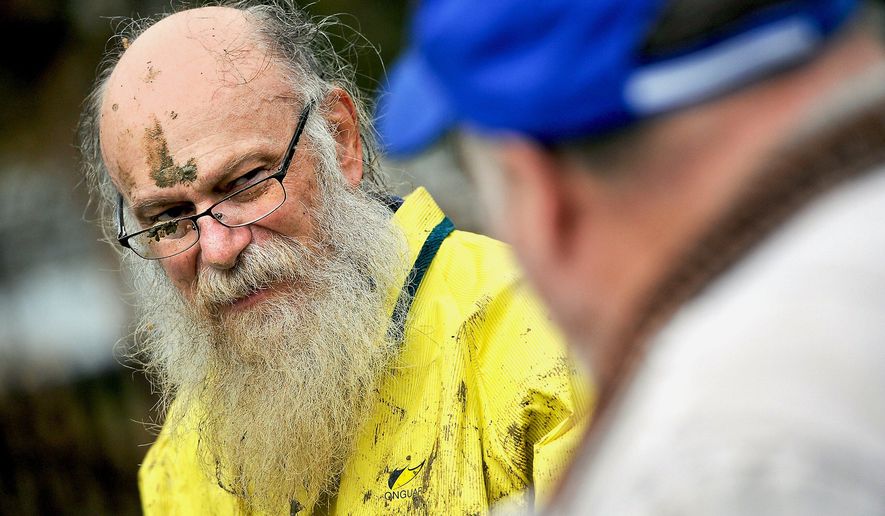 ADVANCE FOR THE WEEKEND OF FEB. 20 - In this Feb. 3, 2016 photo, Jim Fogle of Indiana, covered in mud from crawling underneath the Indiana First Church of the Nazarene, speaks with Barry Watson, right, whose daughter is married to Fogle's son, as he was helping to fix a leaking water pipe at the church in Indiana. (Michael Henninger/Pittsburgh Post-Gazette via AP) MANDATORY CREDIT