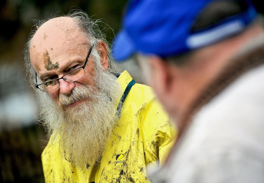 ADVANCE FOR THE WEEKEND OF FEB. 20 - In this Feb. 3, 2016 photo, Jim Fogle of Indiana, covered in mud from crawling underneath the Indiana First Church of the Nazarene, speaks with Barry Watson, right, whose daughter is married to Fogle's son, as he was helping to fix a leaking water pipe at the church in Indiana. (Michael Henninger/Pittsburgh Post-Gazette via AP) MANDATORY CREDIT