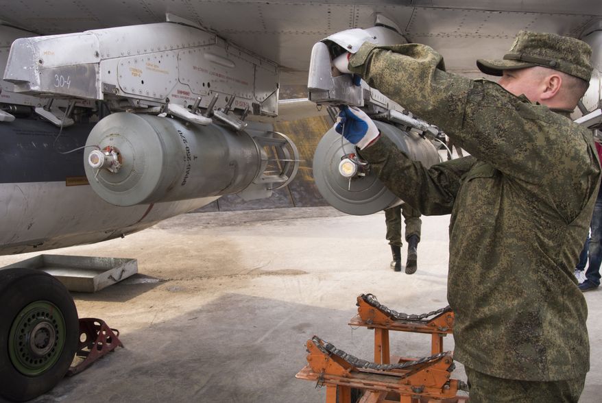 A Russian Air Force technician attaches a bomb to a Russian ground attack jet at Hemeimeem Air Base in Syria on Jan. 20. (Associated Press)