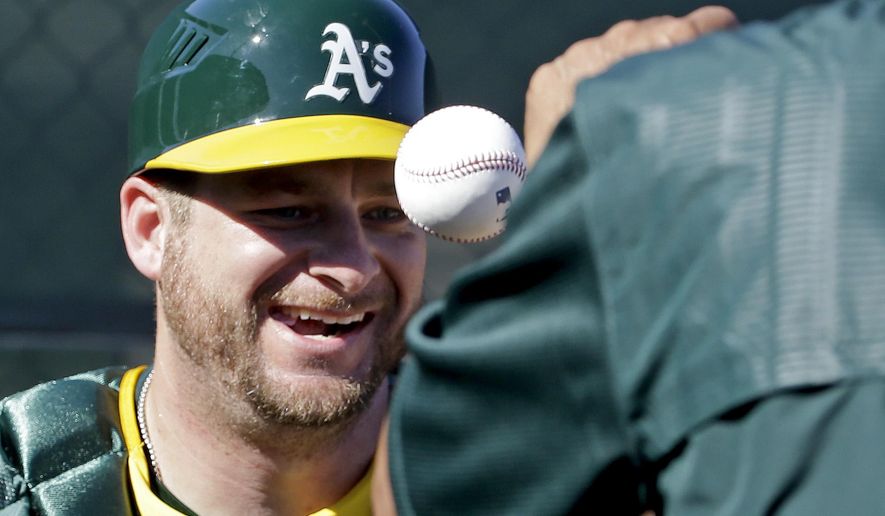 Oakland Athletics catcher Stephen Vogt works on a drill during spring training baseball practice in Mesa, Ariz., Sunday, Feb. 21, 2016. (AP Photo/Chris Carlson)