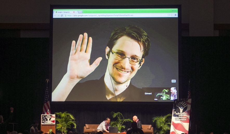 In this Feb. 14, 2015, file photo, Edward Snowden appears on a live video feed broadcast from Moscow at an event sponsored by ACLU Hawaii in Honolulu. (AP Photo/Marco Garcia, File)
