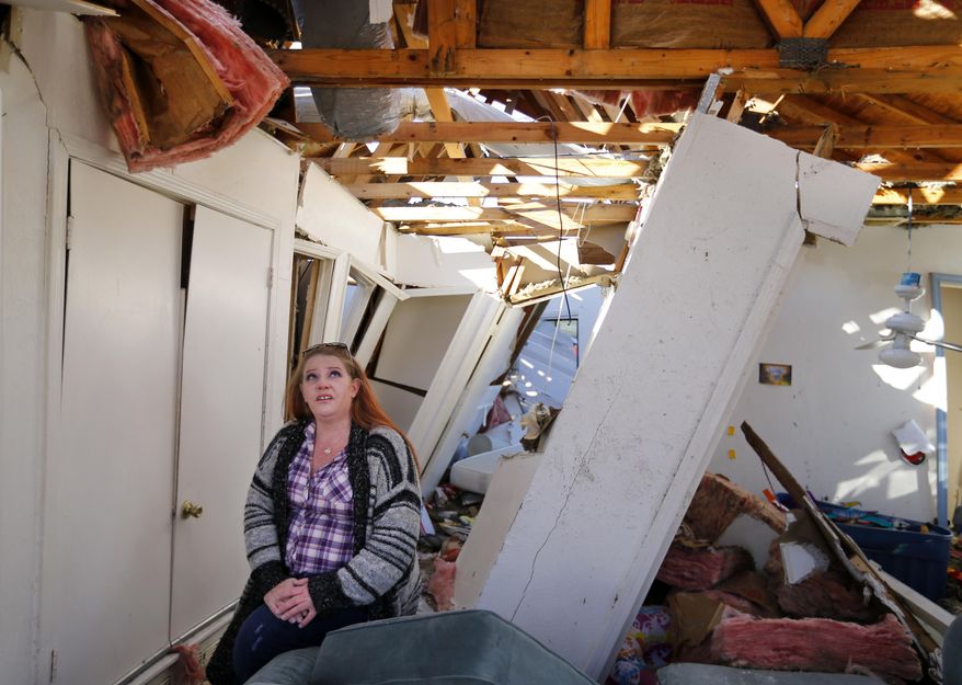 In this Friday, Jan. 22, 2016 photo, homeowner Amanda Bose talks about how her house came apart in her tornado devastated home in Rowlett, Texas. She and her family found safety in the bathroom as the walls of her Fox and Jacobs home collapsed around them. Experts are looking at building standards following late-December tornadoes that slammed parts of North Texas. (Tom Fox/The Dallas Morning News via AP) MANDATORY CREDIT