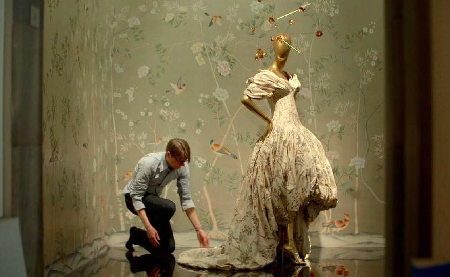 This image released by Magnolia Pictures shows Andrew Bolton adjusting a dress on display in a scene from Andrew Rossi's documentary, "The First Monday in May," about the Metropolitan Museum of Art's costume exhibition on Chinese-inspired Western fashions. The film will open the 15th Tribeca Film Festival, running from April 13-24. (Magnolia Pictures via AP)