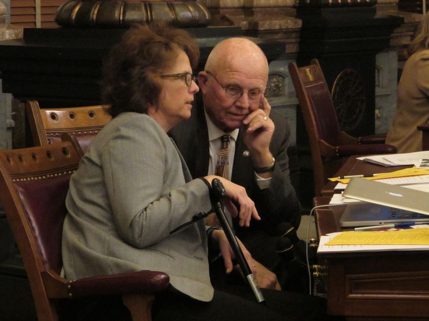 Kansas state Sens. Carolyn McGinn, left, R-Sedgwick, and Ralph Ostmeyer, right, R-Grinnell, confer during a Senate debate on foster care legislation, Monday night, Feb. 22, 2016, at the Statehouse in Topeka, Kan. The legislation would create a new pilot program for having married couples who don’t smoke or drink alcohol serve as foster parents to abused and neglected children. (AP Photo/John Hanna)