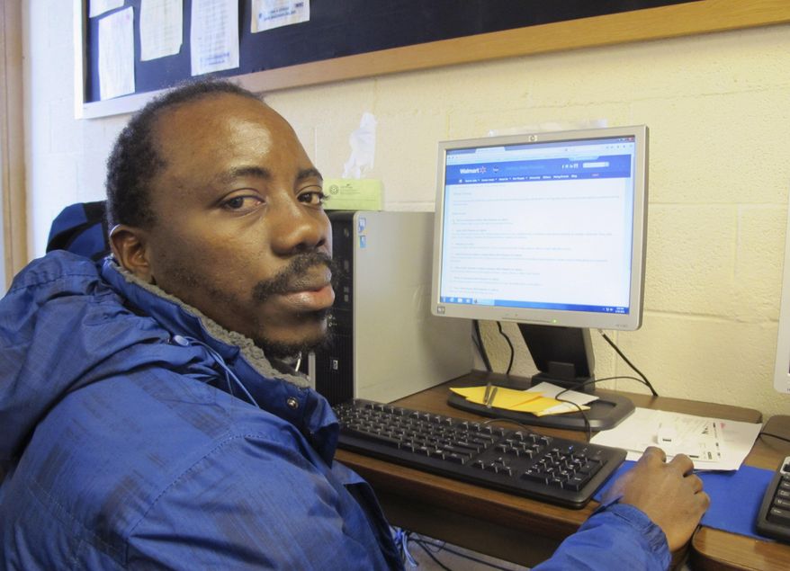 In this Jan. 29, 2016 photo, Kennedy Mugemuzi poses for a photo at the Job Service office in Williston, N.D. Mugemuzi, a native of the Congo, moved to the oil patch city a year ago and works two full-time jobs to support his wife and three children. He is among the optimistic in the city where the oil boom gravy days are waning due to depressed oil prices. (AP Photo/James MacPherson)