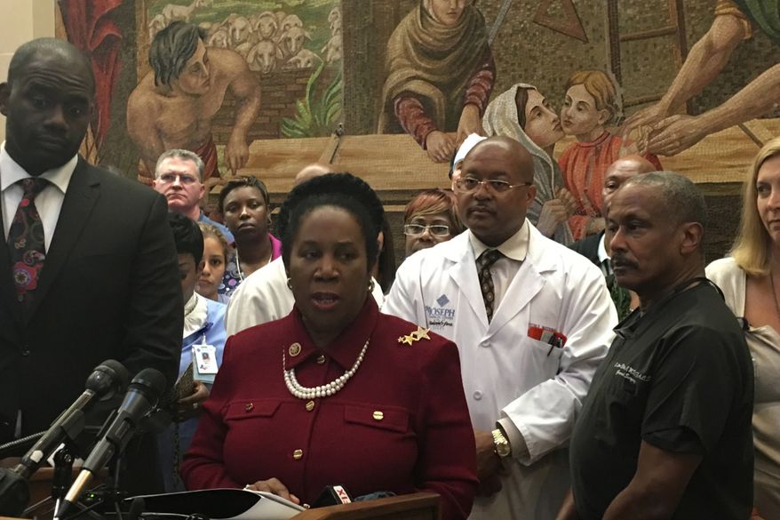 Health care workers and politicians rally Dec. 3 at Houston's St. Joseph Medical Center, which is threatened with a loss federal reimbursements. From left to right: Houston councilman Jerry Davis, U.S. Rep. Sheila Jackson Lee (D-Houston), Dr. Winston Watkins, Jr., and Dr. E. Leon Etter II. Alan Pean, a mentally ill, unarmed, combative patient, was shot by hospital guards on Aug. 27, an incident that sparked a federal probe. (Photo by Carrie Feibel Houston Public Media/website)